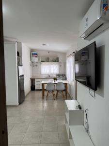 a kitchen with a table and chairs in a room at Casa de 2 dormitorios, zona parque in Necochea +2 photos