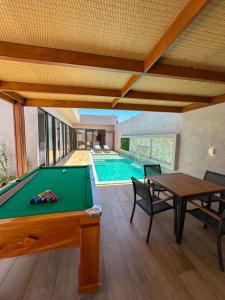 a pool table in a room with a swimming pool at Casa Don Magalhães in Barra de São Miguel