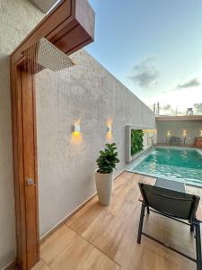a house with a swimming pool and a chair at Casa Don Magalhães in Barra de São Miguel