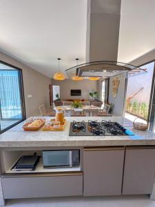 a kitchen with a counter with a stove top oven at Casa Don Magalhães in Barra de São Miguel +38 photos
