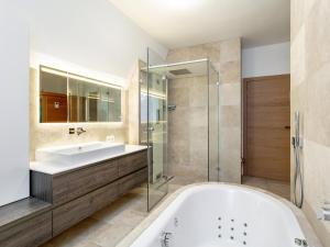 a bathroom with a tub and a sink and a shower at Panorama Loft in Wörgl +32 photos