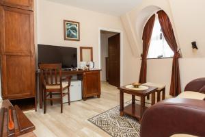 a living room with a couch and a desk at DOWNTOWN ROOMS in Niš