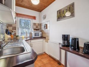 a kitchen with a sink and a microwave at Das Haus am Wald in Waltershausen