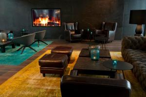 a living room with leather furniture and a fireplace at Motel One München-Campus in Munich +36 photos