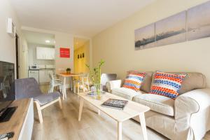 sala de estar con sofá y mesa en Brand New Apartment Near Camp Nou and Fira Barcelona, en Hospitalet de Llobregat