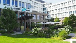 a building with a garden in front of it at Motel One München-Campus in Munich