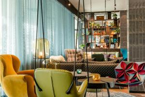 a living room with yellow chairs and a couch at Motel One Salzburg-Süd in Salzburg
