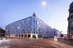 a large white building on a city street at Motel One München-Haidhausen in Munich