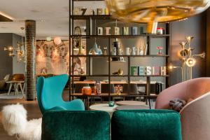 a room with two green chairs and a table at Motel One München-Westend in Munich +19 photos