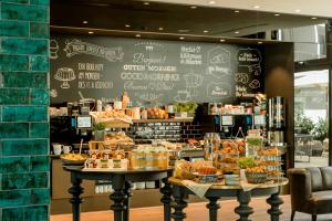 a bakery with a chalkboard wall with various pastries at Motel One München-Haidhausen in Munich