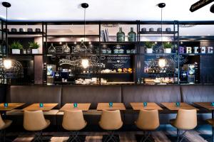 a restaurant with a bar with tables and chairs at Motel One Newcastle in Newcastle upon Tyne