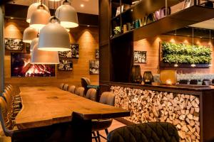 a dining room with a wooden table and chairs at Motel One Salzburg-Süd in Salzburg