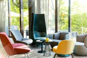 a group of chairs in a room with a table at Motel One Wien-Prater in Vienna +50 photos