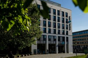 a white building with a sign on the side of it at Motel One Rostock in Rostock