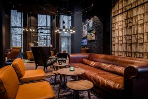 a leather couch in a room with chairs and tables at Motel One Stuttgart-Feuerbach in Stuttgart