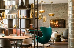 a restaurant with a table and chairs and a fireplace at Motel One München-Westend in Munich