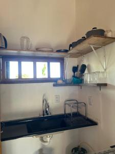 a small kitchen with a sink and a window at Casa Mojubá in Porto Seguro +4 photos