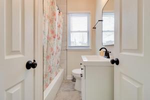 a bathroom with a sink and a toilet and a window at Modern Updates & Great Location! Detroit Duplex in Detroit +17 photos