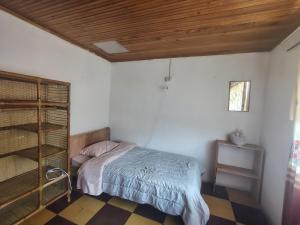 a bedroom with a bed and a wooden ceiling at Hostal Mama Julia - Sede Urbana - Casa Coibrí in Sibundoy