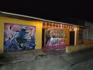 a building with paintings on the side of it at night at Hostal Mama Julia - Sede Urbana - Casa Coibrí in Sibundoy +26 photos