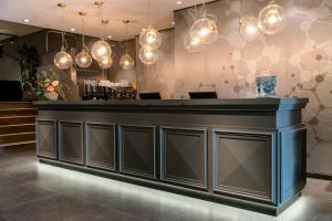 a bar in a restaurant with lights at Motel One Ulm in Ulm