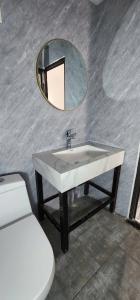 a bathroom with a sink and a mirror and a toilet at SAKURA Retreat in Mộc Châu