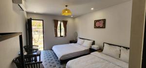 a bedroom with two beds and a window at SAKURA Retreat in Mộc Châu +23 photos