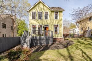 a yellow house with a fence in a yard at Lush, Spacious Intown Retreat in Atlanta