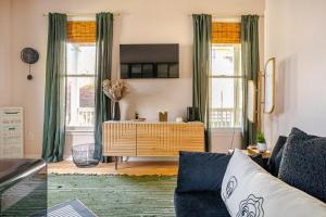 a living room with a couch and two windows at Lush, Spacious Intown Retreat in Atlanta