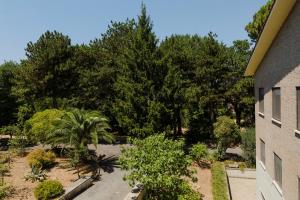 a garden with trees and plants next to a building at OSTELLO del Lago in Grottaferrata
