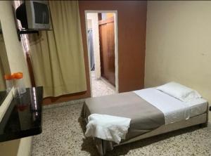 a bedroom with a bed and a tv on a wall at HOTEL Nevada Palace in Mérida +18 photos