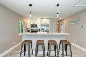 a kitchen with three stools at a counter at Ami Gulf Lookout-Views Of The Gulf From Every Room-Rooftop Terrace in Bradenton Beach