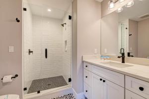 a white bathroom with a shower and a sink at Ami Gulf Lookout-Views Of The Gulf From Every Room-Rooftop Terrace in Bradenton Beach