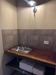 a bathroom with a sink and a counter with towels at Cabañas El Alemán in Cerrillos +17 photos