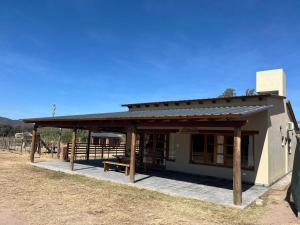 a small building with a roof on a field at Cabañas El Alemán in Cerrillos