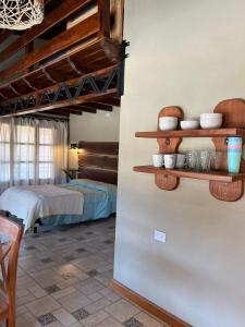 a room with a bed and shelves on the wall at Cabañas El Alemán in Cerrillos