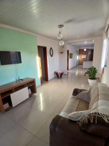 a living room with a couch and a flat screen tv at Brisa Tropical in Ilhéus