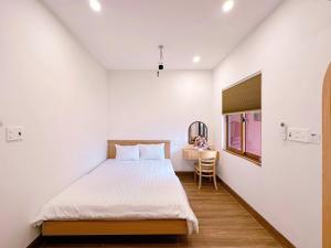 a bedroom with a bed and a desk in it at DEE Homestay in Hue +25 photos