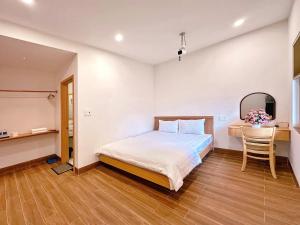 a bedroom with a bed and a table and a chair at DEE Homestay in Hue