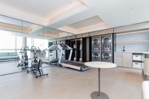 a gym with treadmills ellipticals and machines in a room at JI Hotel Suzhou Wujiang Development Zone in Suzhou