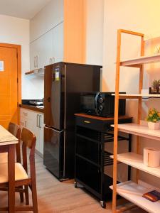 a kitchen with a black refrigerator and a microwave at The Infinity View in Talisay