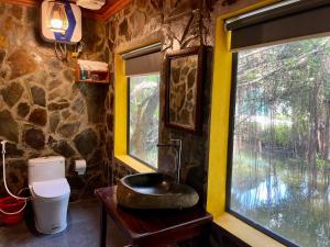 a stone bathroom with a sink and a window at Trang An Mountain Ecologe in Xuân Sơn +29 photos