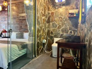 a bathroom with a shower with a bed and a sink at Trang An Mountain Ecologe in Xuân Sơn