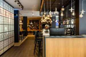 a bar in a restaurant with a counter and stools at Motel One Madrid-Plaza de España in Madrid