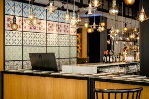 a bar with a laptop on top of a counter at Motel One Madrid-Plaza de España in Madrid