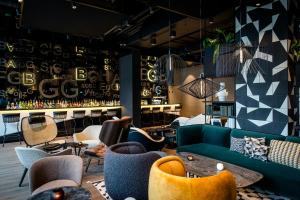 a lobby with couches and chairs and a bar at Motel One Karlsruhe in Karlsruhe