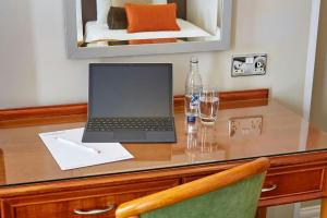 Ein Laptop steht auf einem Holzschreibtisch in der Unterkunft Lancaster Gate Hotel in London + 17 Fotos