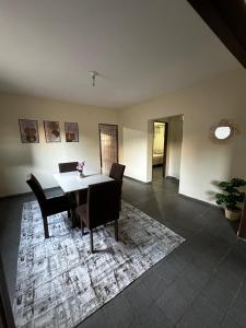 a dining room with a table and chairs on a rug at 3R acomodações in Juazeiro do Norte