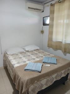 a bed in a room with two towels on it at Brisa Tropical in Ilhéus +21 photos