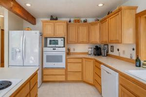 a kitchen with wooden cabinets and white appliances at Pine Tree Cottage by NW Comfy Cabins in Leavenworth +50 photos